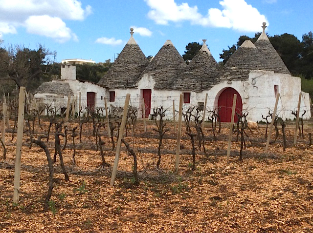 trullo with red doors and grapevines